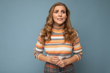 Photo portrait of young attractive beautiful sad upset touchy concernes worried blonde woman with sincere emotions wearing striped pullover isolated on blue background with copy space