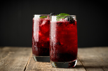 Blackberry cocktail with crushed ice on the rustic wooden background. Selective focus. Shallow...