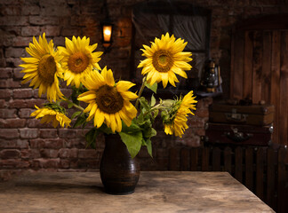 Beautiful bouquet of sunflowers in vase on a wooden table