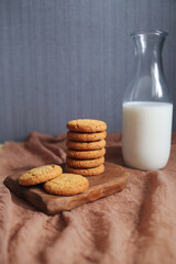 cookies on a wooden board and milk in a glass bottle