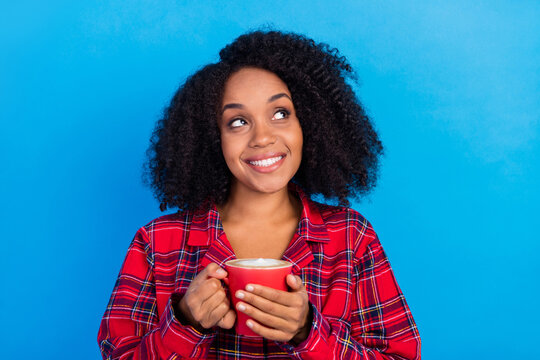 Photo of relax young lady drink coffee look empty space wear red checkered pajama isolated on blue color background