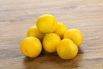 Ripe sweet yellow plum heap over background