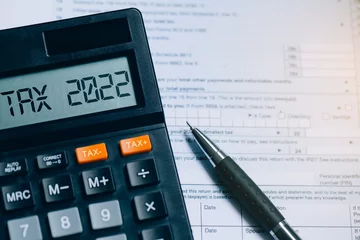 Fotobehang Word Tax 2022 on the calculator on documents.Income Statement. paying the tax rate. Taxation, taxes burden.Business and tax concept. © Pcess609