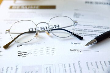 Resignation letter information with a pen and glasses on the table.