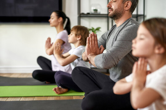 Crop of family with kids practice yoga meditate