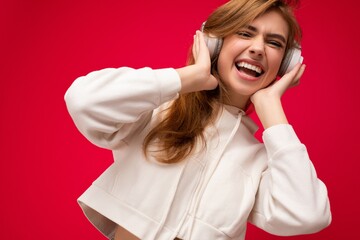 Closeup photo of attractive positive smiling young blonde woman wearing white hoodie isolated over...