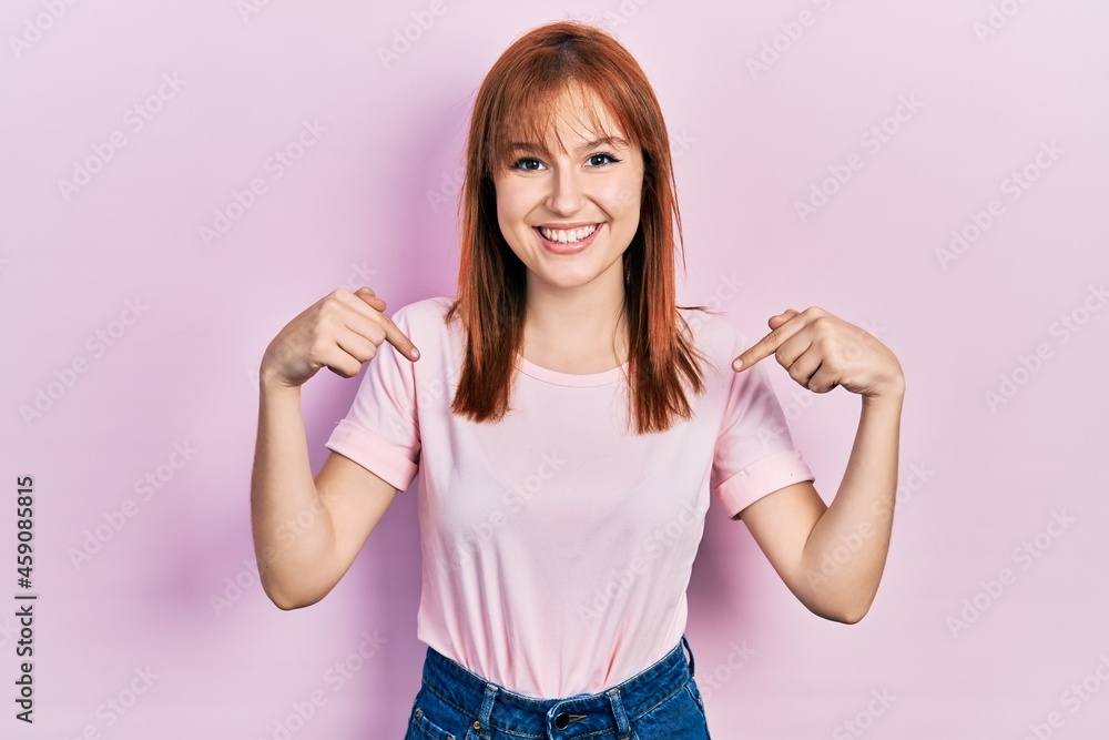 Sticker Redhead young woman wearing casual pink t shirt looking confident with smile on face, pointing oneself with fingers proud and happy.