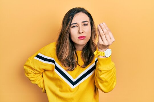 Young hispanic girl wearing casual clothes doing italian gesture with hand and fingers confident expression