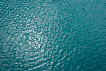 turquoise blue water texture and reflections of sunlight abstract nature background for relaxation