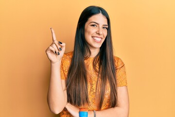 Obraz premium Young hispanic woman wearing casual clothes smiling with an idea or question pointing finger up with happy face, number one