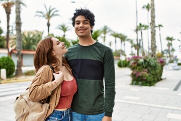 Fototapeta premium Young interracial couple smiling happy and hugging standing at the city.