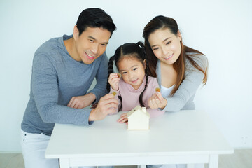 Asian family, father mother and daughter together saving money