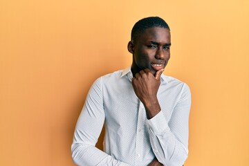 Young african american man wearing casual clothes smiling looking confident at the camera with crossed arms and hand on chin. thinking positive.