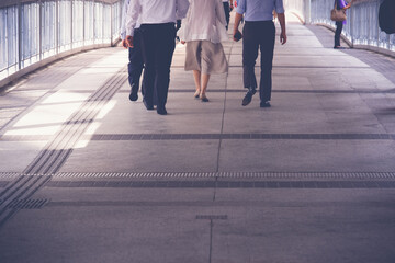 legs of business people walking on sidewalk on rush hour