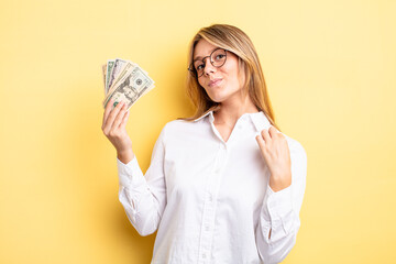pretty blonde girl looking arrogant, successful, positive and proud. dollar banknotes concept