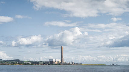 Obraz premium Large factory or plant with tall chimney and industrial harbour on the Northern Ireland coast, Carrickfergus town, County Antrim