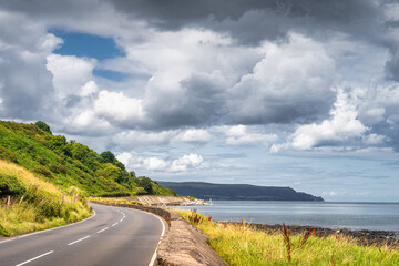 Winding road leading trough coastline to the mountains on far distance, Wild Atlantic Way, Northern Ireland