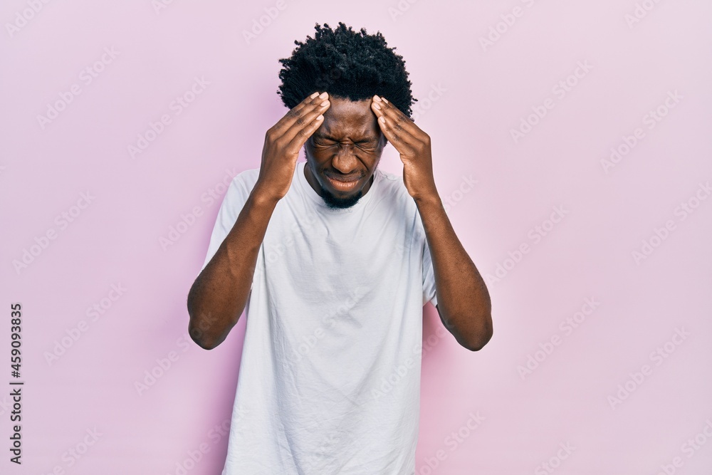 Sticker Young african american man wearing casual white t shirt with hand on head for pain in head because stress. suffering migraine.