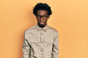 Young african american man wearing casual clothes and glasses skeptic and nervous, frowning upset because of problem. negative person.