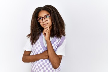 Young african american girl standing over isolated background serious face thinking about question with hand on chin, thoughtful about confusing idea