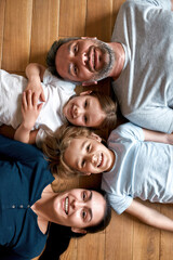 Portrait of smiling parents with kids lying on floor