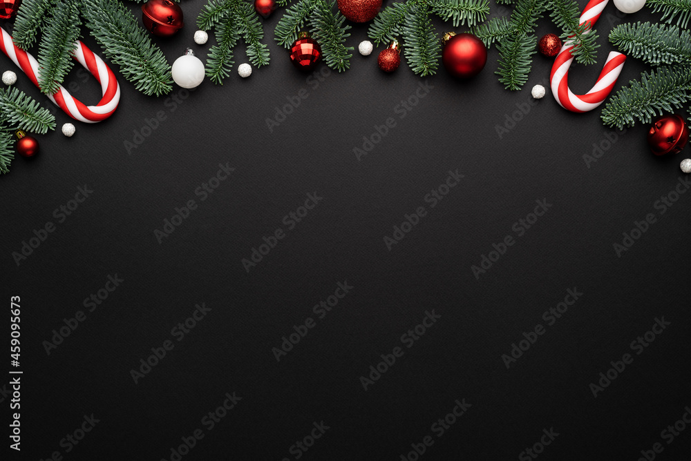 Wall mural Frame made of Christmas ornaments fir branches on a black background