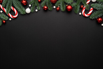 Frame made of Christmas ornaments fir branches on a black background