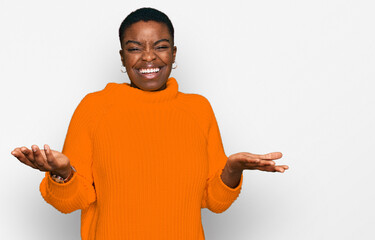 Young african american woman wearing casual clothes clueless and confused expression with arms and...