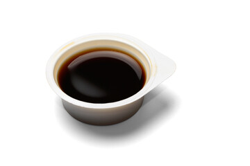 Plastic open disposable container with soy sauce. Isolated on a white background with a shadow, close-up