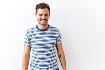 Obraz premium Handsome young man standing over isolated background winking looking at the camera with sexy expression, cheerful and happy face.