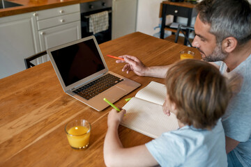 Fototapeta na wymiar Caring dad help teen son with school online studying