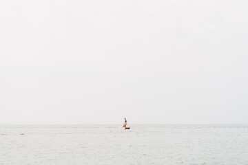 Fototapeta premium woman playing with her dog in the sea water, border terrier, cute little dog 