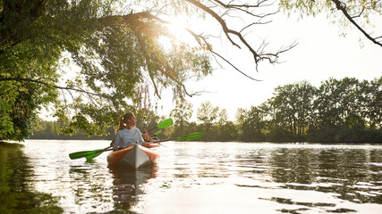 Friends kayaking together in river at spring or summer, spending time together outdoors