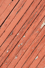 Texture of planks of old wood with peeling red paint