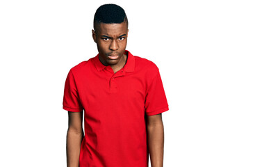 Young african american man wearing casual red t shirt skeptic and nervous, frowning upset because...