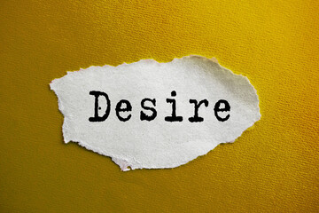 The inscription DESIRE on torn paper. Marketing conceptual word on yellow background.