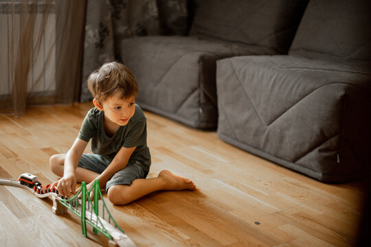 little boy 5 years old playing wooden railroad at home. child playing with toys