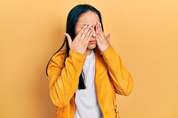 Beautiful hispanic woman with nose piercing wearing yellow leather jacket rubbing eyes for fatigue and headache, sleepy and tired expression. vision problem