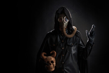 Post-apocalyptic world, concept. A gloomy servant of the devil cult in a black hood - obrazy, fototapety, plakaty