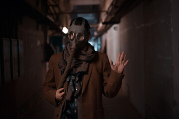 Fototapeta na wymiar A post-apocalyptic concept. A woman in a gas mask