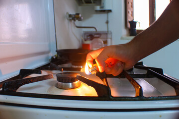 person lighting a fire on a butane stove - obrazy, fototapety, plakaty