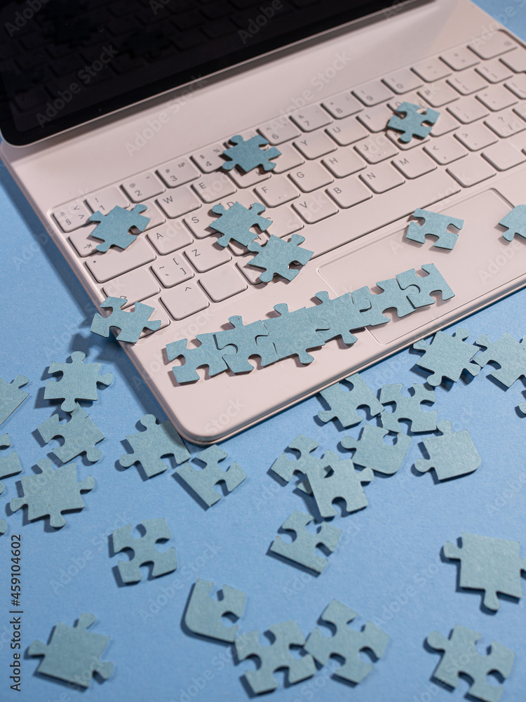 Poster puzzle elements on a laptop keyboard, software development, concept.