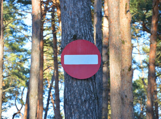 stop sign no entry into the forest on a pine tree - obrazy, fototapety, plakaty