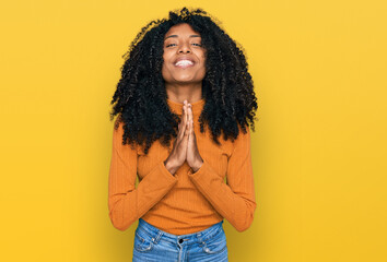 Young african american girl wearing casual clothes praying with hands together asking for forgiveness smiling confident.