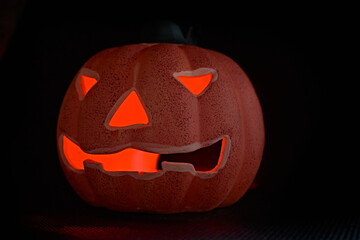A glowing carved pumpkin in a black background - halloween concept