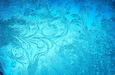 Beautiful blue frost patterns on frozen window as a symbol of Christmas wonder. Christmas or New year background.