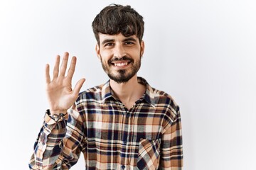 Fototapeta premium Hispanic man with beard standing over isolated background showing and pointing up with fingers number five while smiling confident and happy.