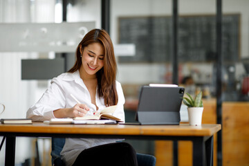 Fototapeta na wymiar Portrait of Beautiful young smiling Asian entrepreneur businesswoman working whit laptop computer in modern office.