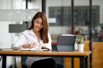 Obraz premium Portrait of Beautiful young smiling Asian entrepreneur businesswoman working whit laptop computer in modern office.