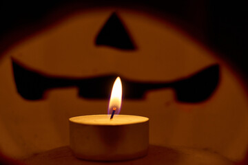 A candle inside a carved pumpkin - halloween concept